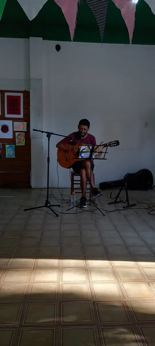 Músico con guitarra y luz natural entrando por la ventana